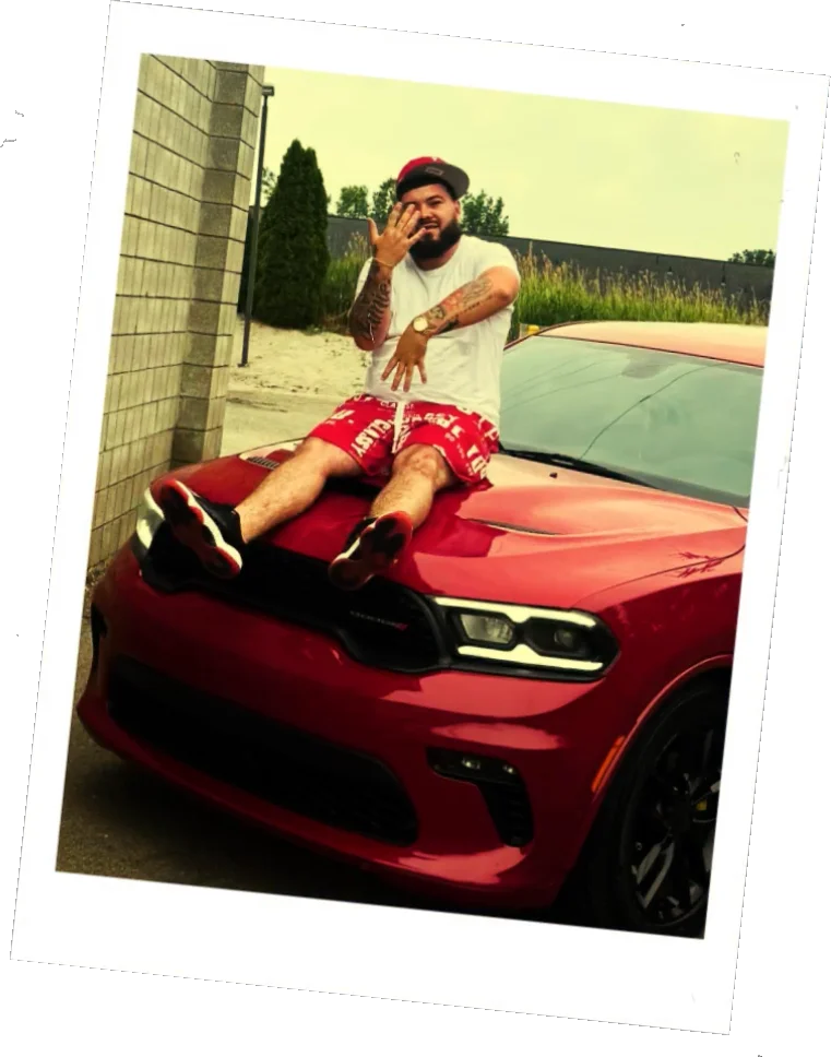 Jackson, Rep. Thompson's son, sitting on the hood of a red SUV